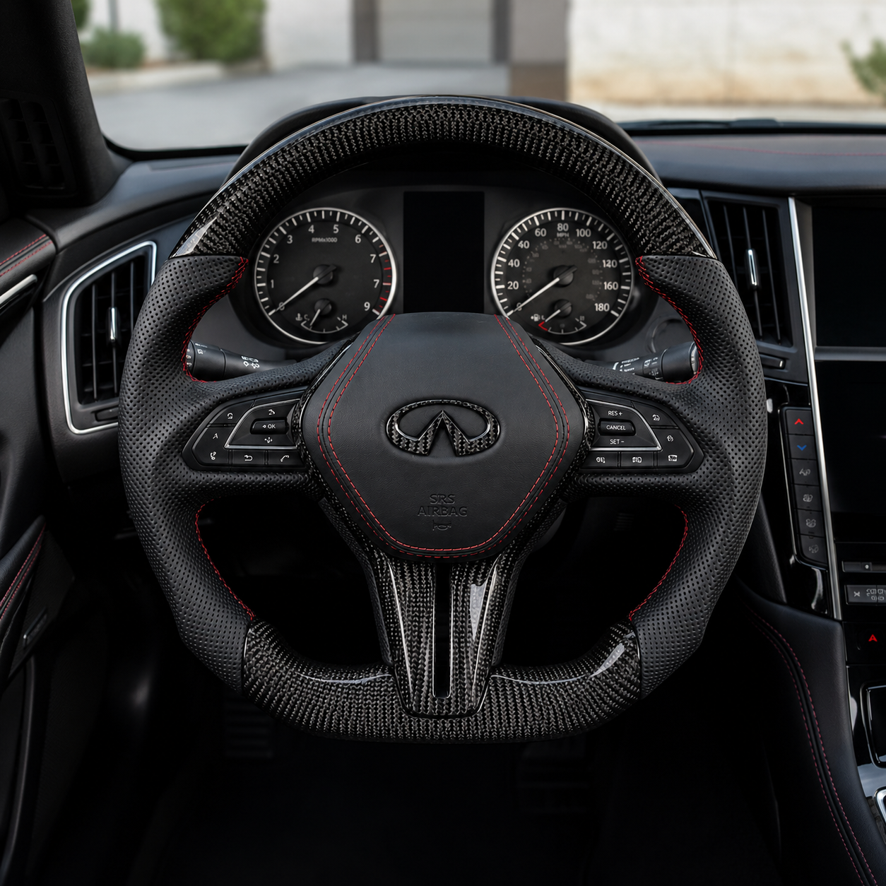 Infiniti Q60 carbon fiber steering wheel installed in cockpit with perforated leather grips red stitching and sporty flat bottom design by CJ Mod Garage