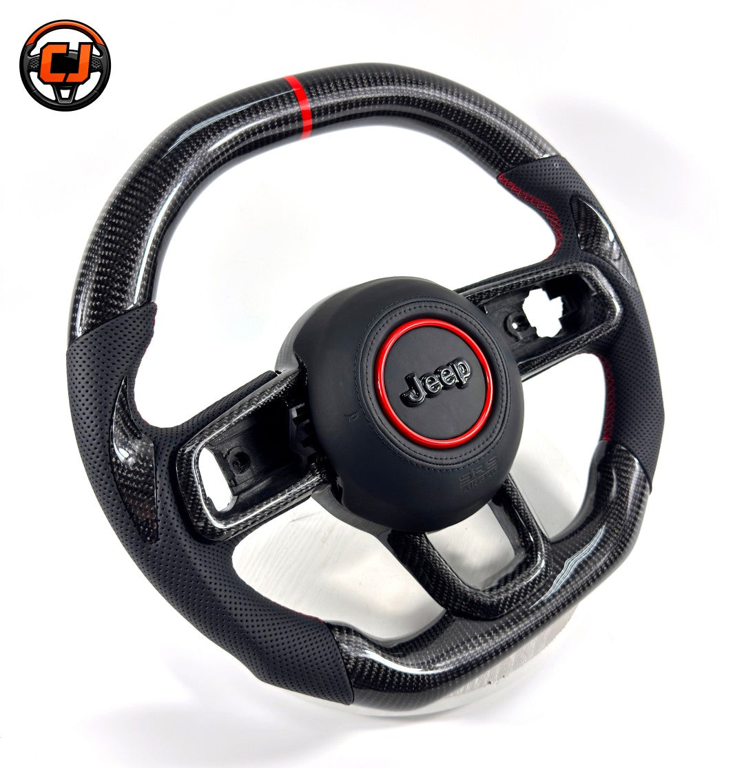Custom carbon fiber steering wheel for Jeep Wrangler with glossy woven carbon fiber, black perforated leather grips, red 12 o'clock stripe, red stitching and black Jeep airbag cover