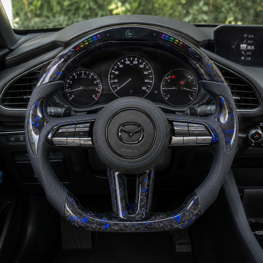 Custom Mazda 3 LED steering wheel in vehicle interior with blue forged carbon trim blue stitching and multifunction buttons