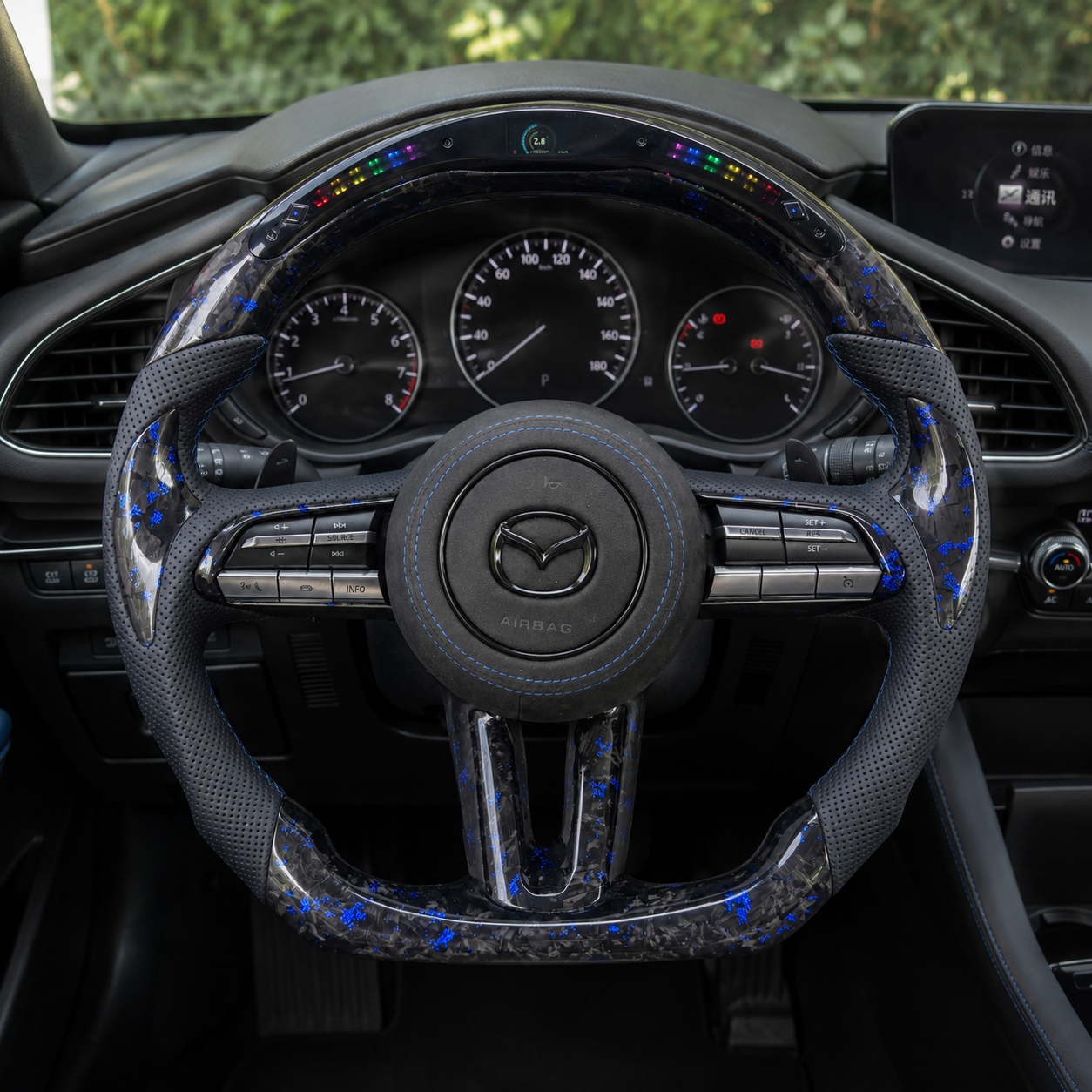 Custom Mazda 3 LED steering wheel in vehicle interior with blue forged carbon trim blue stitching and multifunction buttons