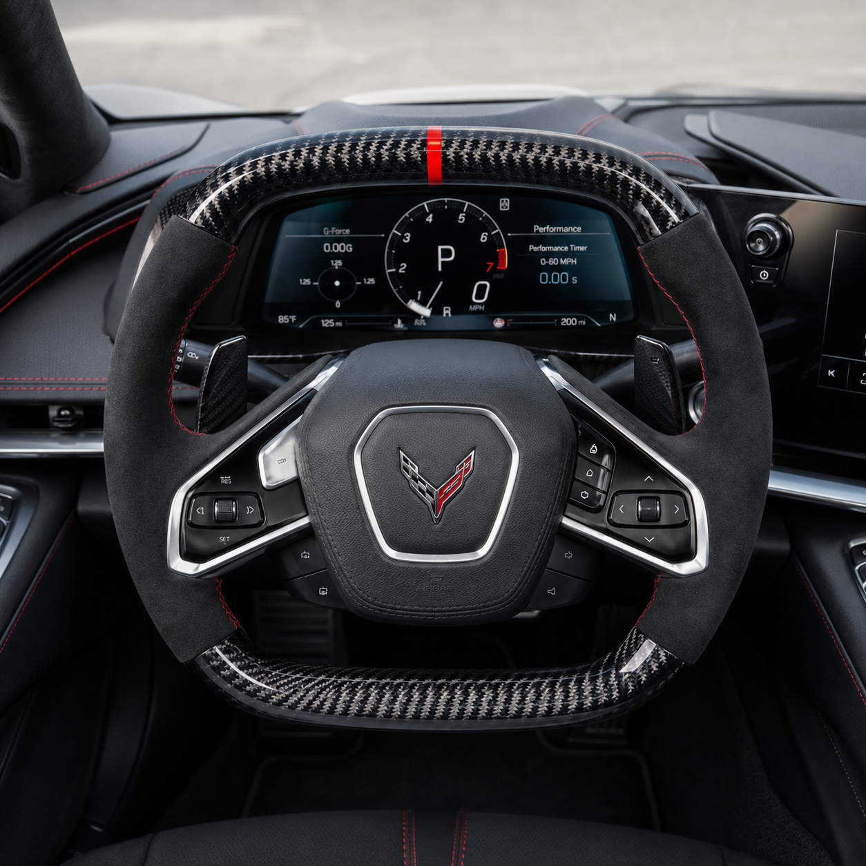 custom Corvette C8 carbon fiber steering wheel cockpit view with black suede grips red stitching paddle shifters and performance dashboard