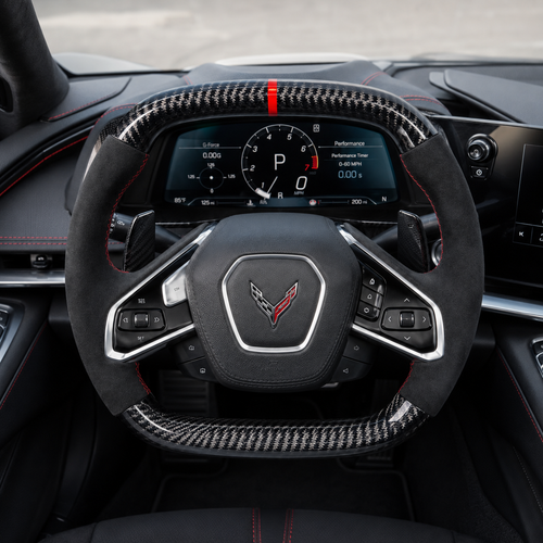 custom Corvette C8 carbon fiber steering wheel cockpit view with black suede grips red stitching paddle shifters and performance dashboard