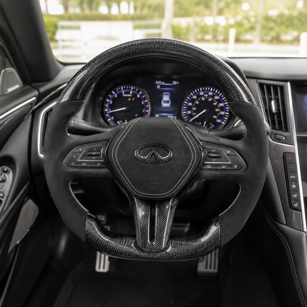 Infiniti Q60 custom carbon fiber steering wheel installed in vehicle interior with Alcantara grips white stitching and matching carbon fiber airbag cover by CJ Mod Garage