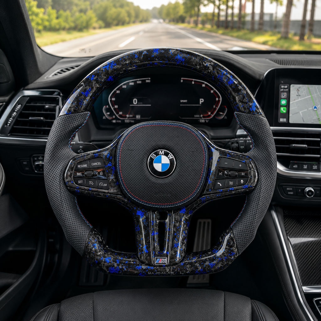 BMW forged carbon fiber custom steering wheel with electric-blue flakes installed in BMW interior, flat-bottom M-style design with perforated leather grips and tri-color stitching, compatible with BMW G02 G05 G06 G09 G11 G12 G15 G20 G22 G28 G29 G30 G38 G80 G82 F40 F90 models – CJ Mod Garage