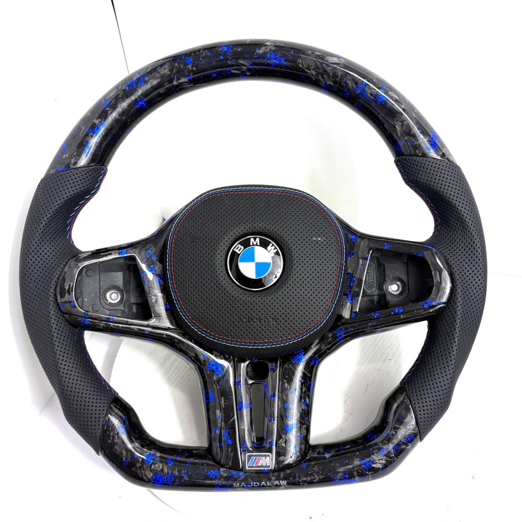 BMW forged carbon fiber steering wheel with blue flakes and perforated leather side grips on white background, custom flat-bottom performance steering wheel for BMW G02 G05 G06 G09 G11 G12 G15 G20 G22 G28 G29 G30 G38 G80 G82 F40 F90 – CJ Mod Garage