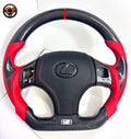 Close up product image of custom Lexus IS carbon fiber steering wheel with red perforated leather sides, black airbag cover, red stitching and carbon fiber Lexus emblem