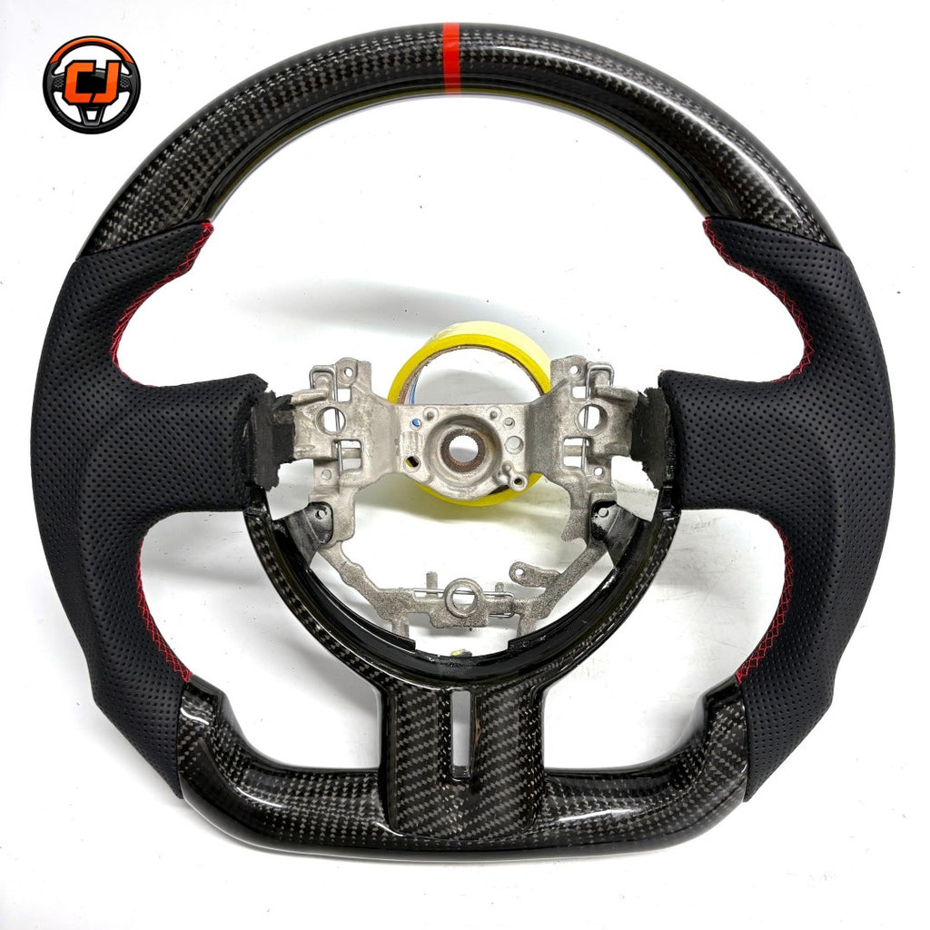 Custom Toyota GT86 steering wheel built with premium carbon fiber and perforated leather, accented by red stitching and racing-inspired center marker by CJ Mod Garage