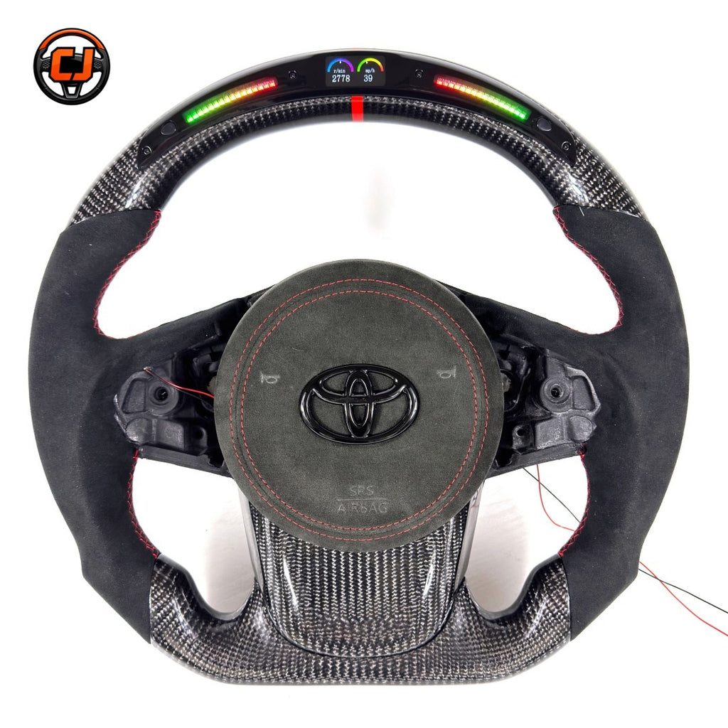 Toyota GR Supra A90 A91 performance steering wheel built with carbon fiber construction, LED RPM indicator, Alcantara grip sections and red center marker by CJ Mod Garage