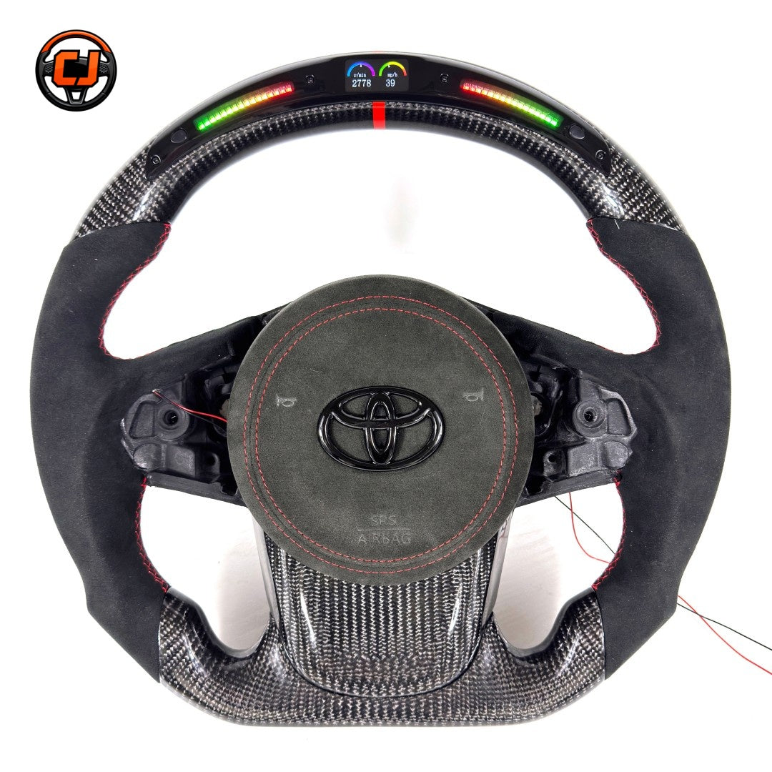 Toyota GR Supra A90 A91 performance steering wheel built with carbon fiber construction, LED RPM indicator, Alcantara grip sections and red center marker by CJ Mod Garage