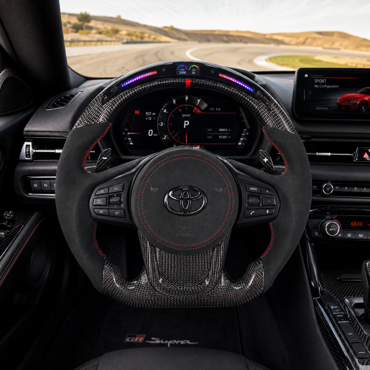 Toyota GR Supra A90 A91 custom carbon fiber steering wheel with LED shift indicator, Alcantara grips, red stitching and digital display cockpit view by CJ Mod Garage