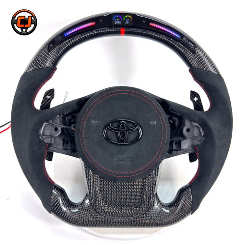 Custom Toyota GR Supra A90 A91 steering wheel crafted with premium carbon fiber, Alcantara wrapping, integrated LED shift lights, red center stripe and paddle shifters by CJ Mod Garage