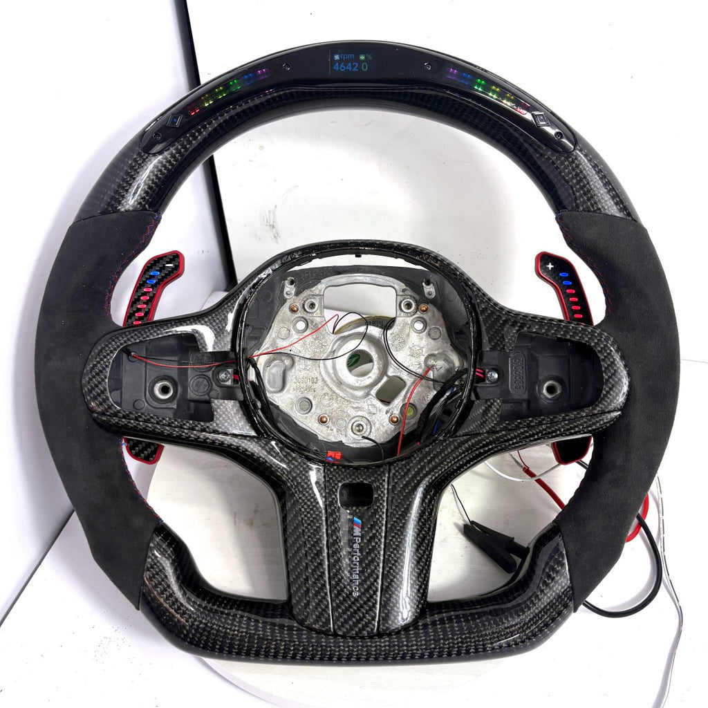 BMW G-series custom carbon fiber steering wheel frame with LED display, Alcantara side grips, illuminated paddle shifters, and round airbag mounting layout for BMW G02 G05 G06 G09 G11 G12 G15 G20 G22 G28 G29 G30 G38 G80 G82 F40 F90