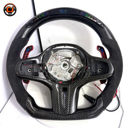 BMW G-series custom carbon fiber steering wheel frame with LED display, Alcantara side grips, illuminated paddle shifters, and round airbag mounting layout for BMW G02 G05 G06 G09 G11 G12 G15 G20 G22 G28 G29 G30 G38 G80 G82 F40 F90