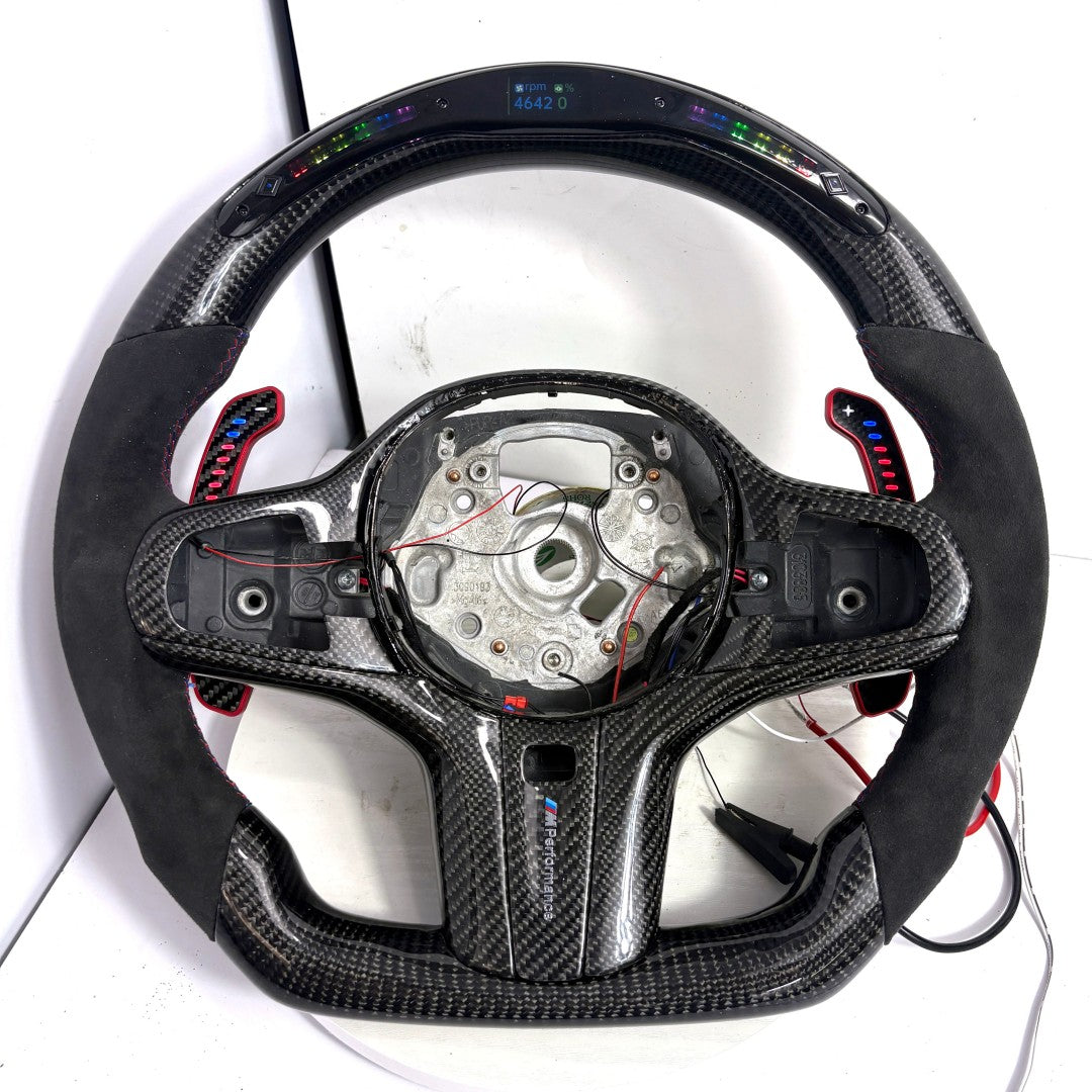BMW G-series custom carbon fiber steering wheel frame with LED display, Alcantara side grips, illuminated paddle shifters, and round airbag mounting layout for BMW G02 G05 G06 G09 G11 G12 G15 G20 G22 G28 G29 G30 G38 G80 G82 F40 F90