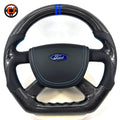 Custom Ford Focus Mk3 Mk3.5 steering wheel crafted from real carbon fiber with perforated leather grip zones, blue accent stripe and performance-inspired styling by CJ Mod Garage
