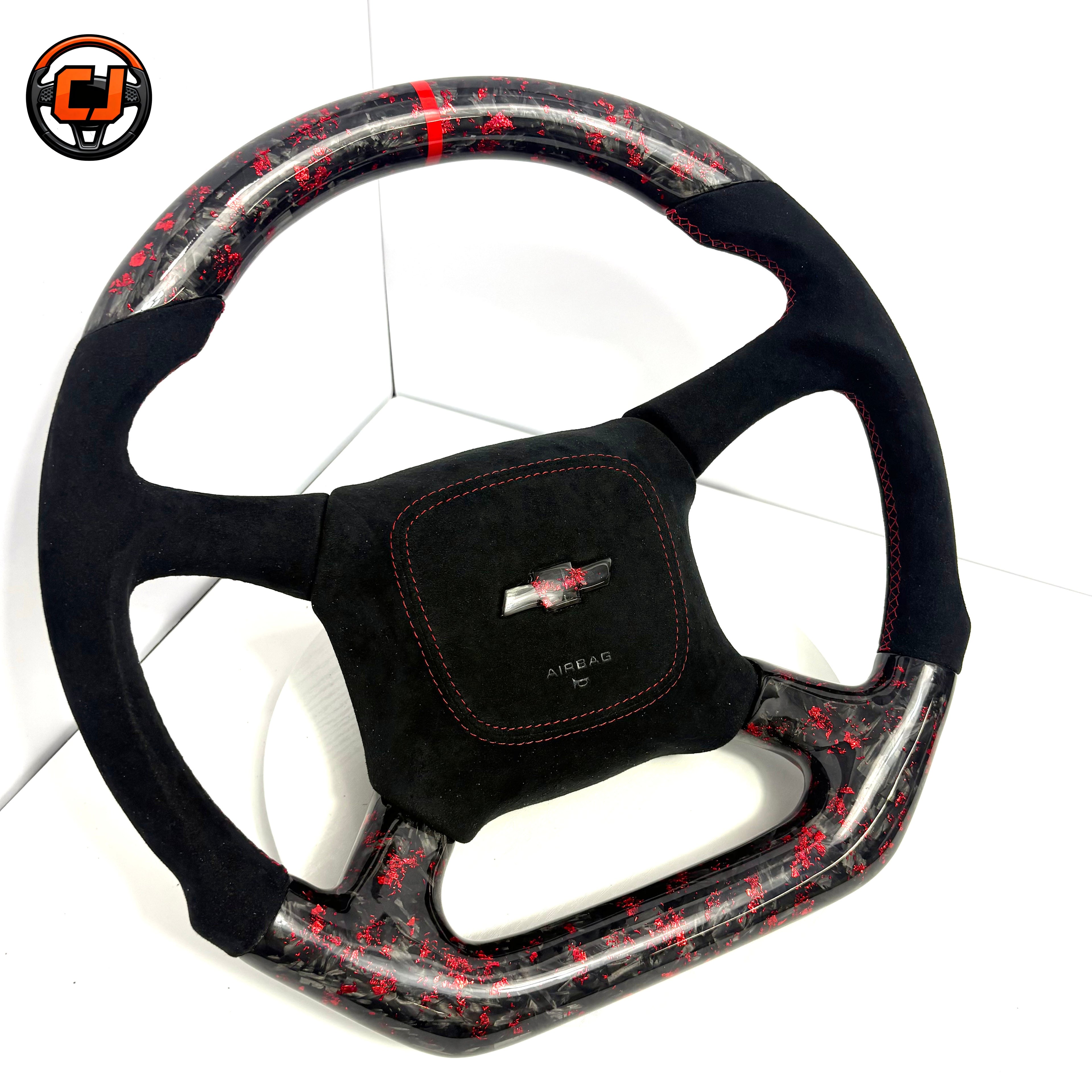 Custom Chevrolet steering wheel with black suede grip, red contrast stitching, red flake forged carbon fiber trim, red 12 o'clock center stripe and Chevrolet airbag cover