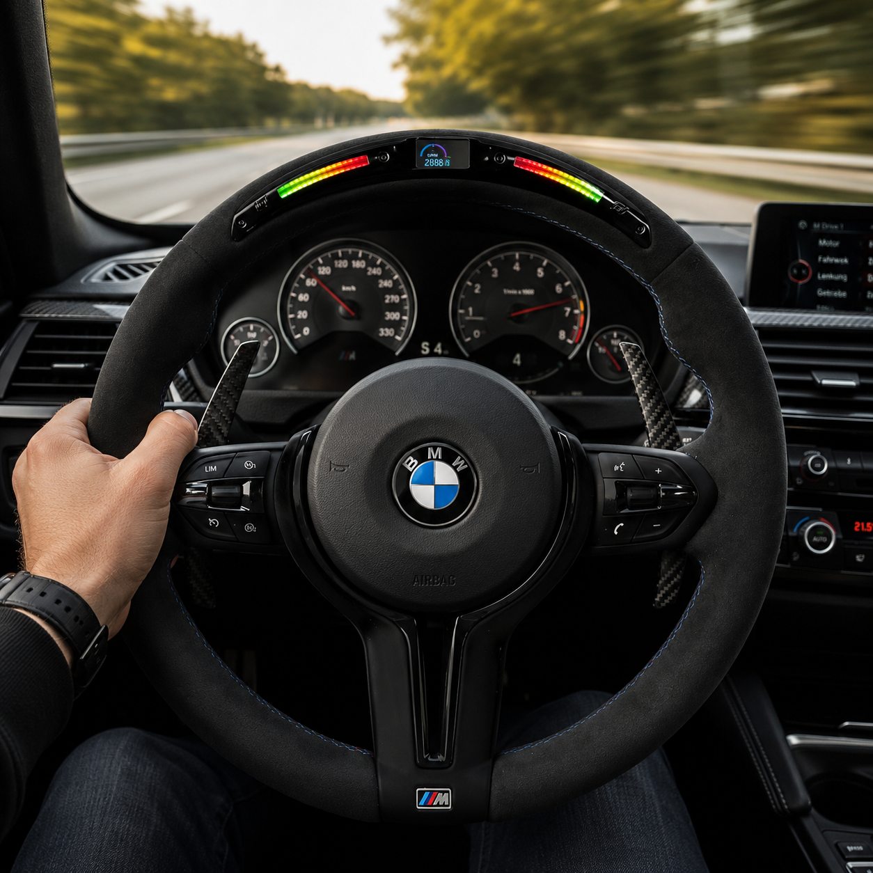 BMW F Series LED performance steering wheel with Alcantara grip and carbon paddle shifters installed in vehicle interior driving view