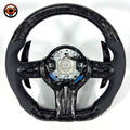 Black forged carbon fiber BMW steering wheel with perforated leather side grips, multifunction controls, paddle shifters, and exposed airbag mounting structure compatible with BMW F10 F11 F15 F18 F20 F23 F25 F30 F32 F35 F40 F80 E84 E87 E90 E92 E93