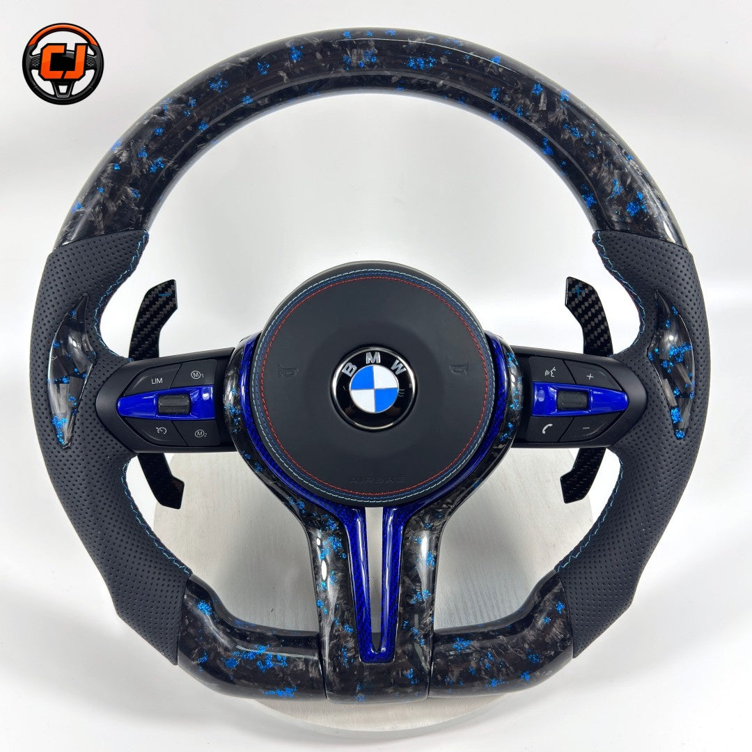 BMW forged carbon steering wheel with blue marble carbon finish, blue center accent, black perforated leather grips, carbon paddle shifters, and round airbag cover for BMW F10 F11 F15 F18 F20 F23 F25 F30 F32 F35 F40 F80 E84 E87 E90 E92 E93
