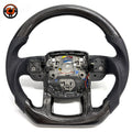 Studio product photo of custom Range Rover Evoque carbon fiber steering wheel with black perforated leather grips, flat bottom carbon fiber trim and exposed central mounting structure