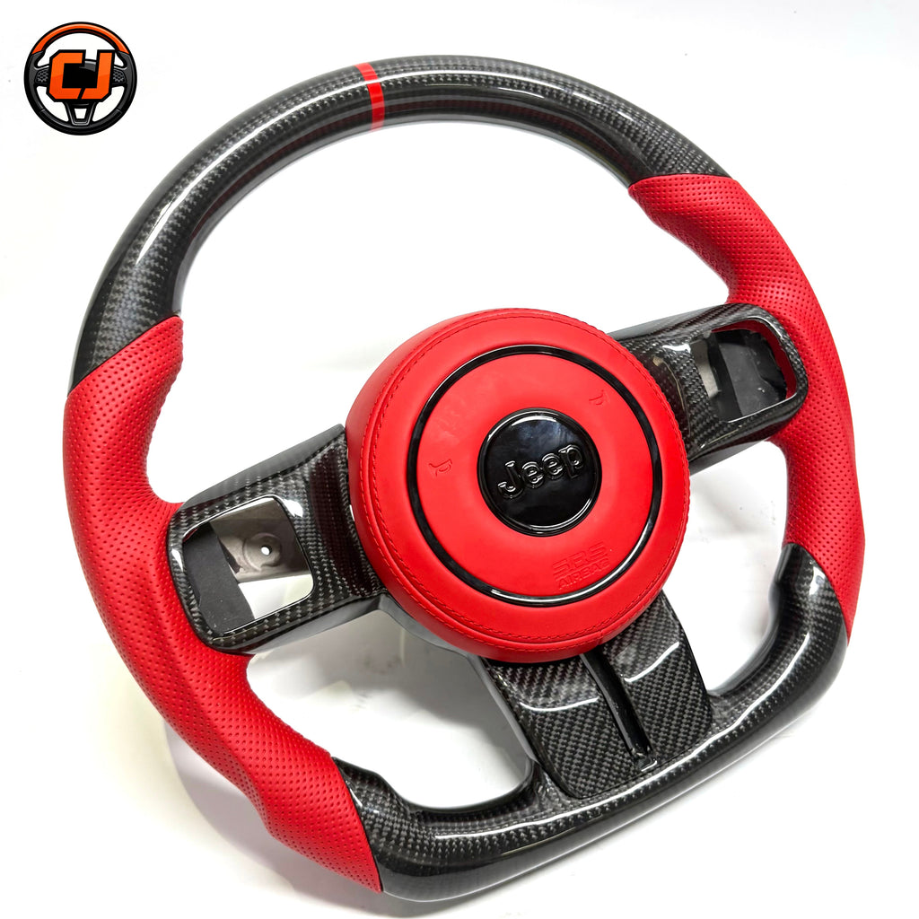Custom carbon fiber steering wheel for Jeep Wrangler with red perforated leather grips, red leather airbag cover, glossy carbon fiber trim and red 12 o'clock center stripe