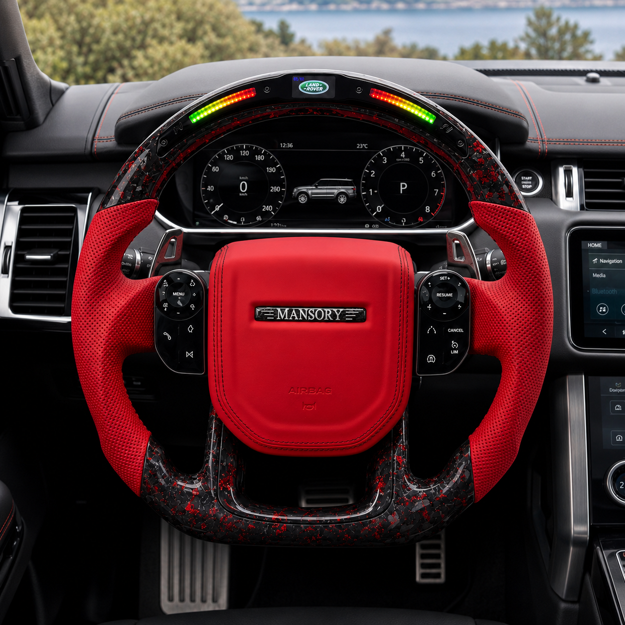 Front interior view of custom Land Rover Range Rover steering wheel with red leather airbag cover, red perforated side grips, LED shift light display and forged carbon fiber with red flakes