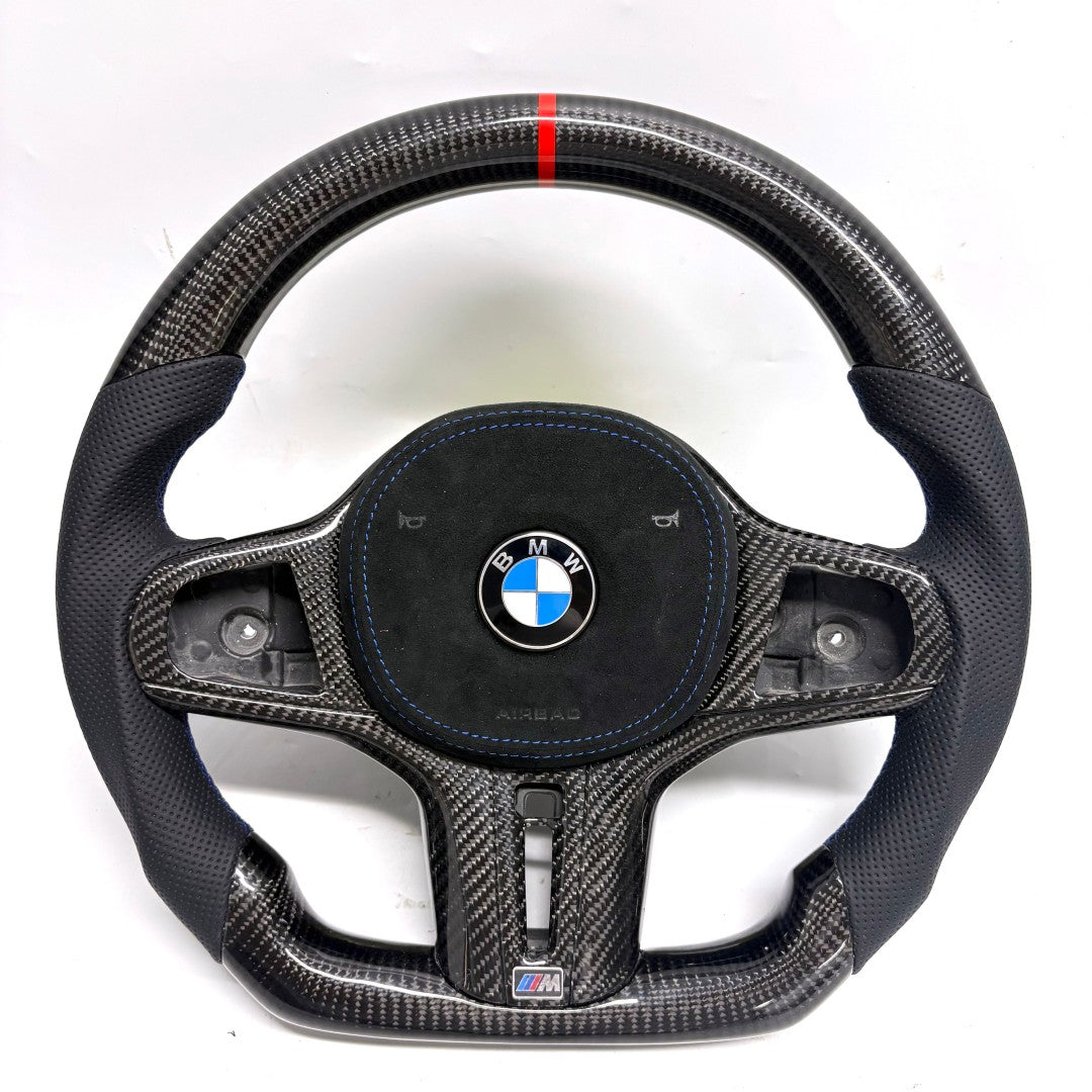 BMW G-chassis carbon fiber steering wheel on white background featuring perforated leather grips, blue stitching, flat-bottom performance contour, and red top center marker for BMW G02 G05 G06 G09 G11 G12 G15 G20 G22 G28 G29 G30 G38 G80 G82 F40 F90