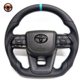 Toyota Land Cruiser LC300 handcrafted leather steering wheel with perforated grip sections, blue contrast stitching, OEM airbag cover and factory-style controls by CJ Mod Garage