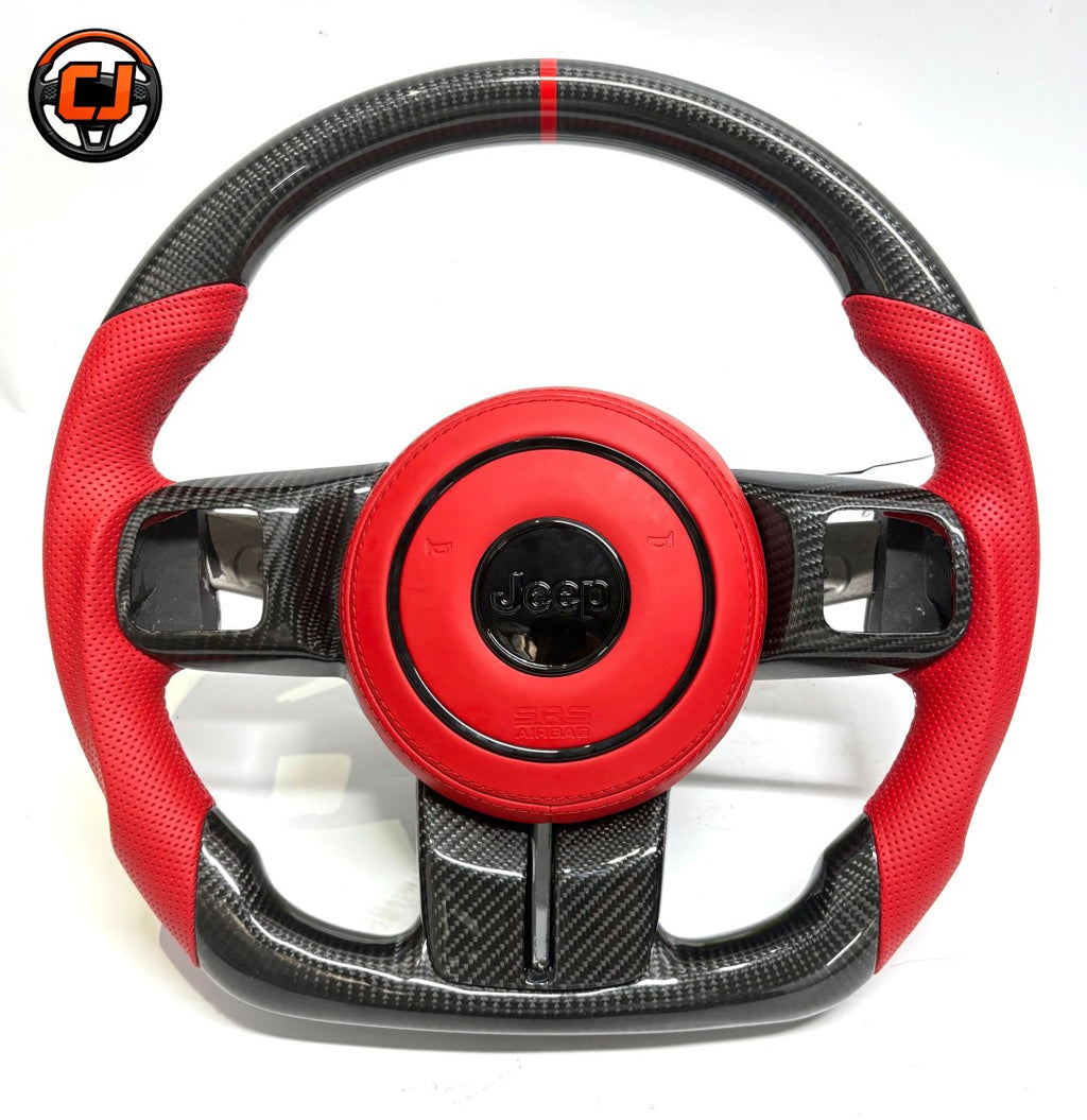 Studio front view of custom Jeep Wrangler carbon fiber steering wheel with red perforated leather grips, red leather airbag cover, red 12 o'clock stripe and flat bottom sport design
