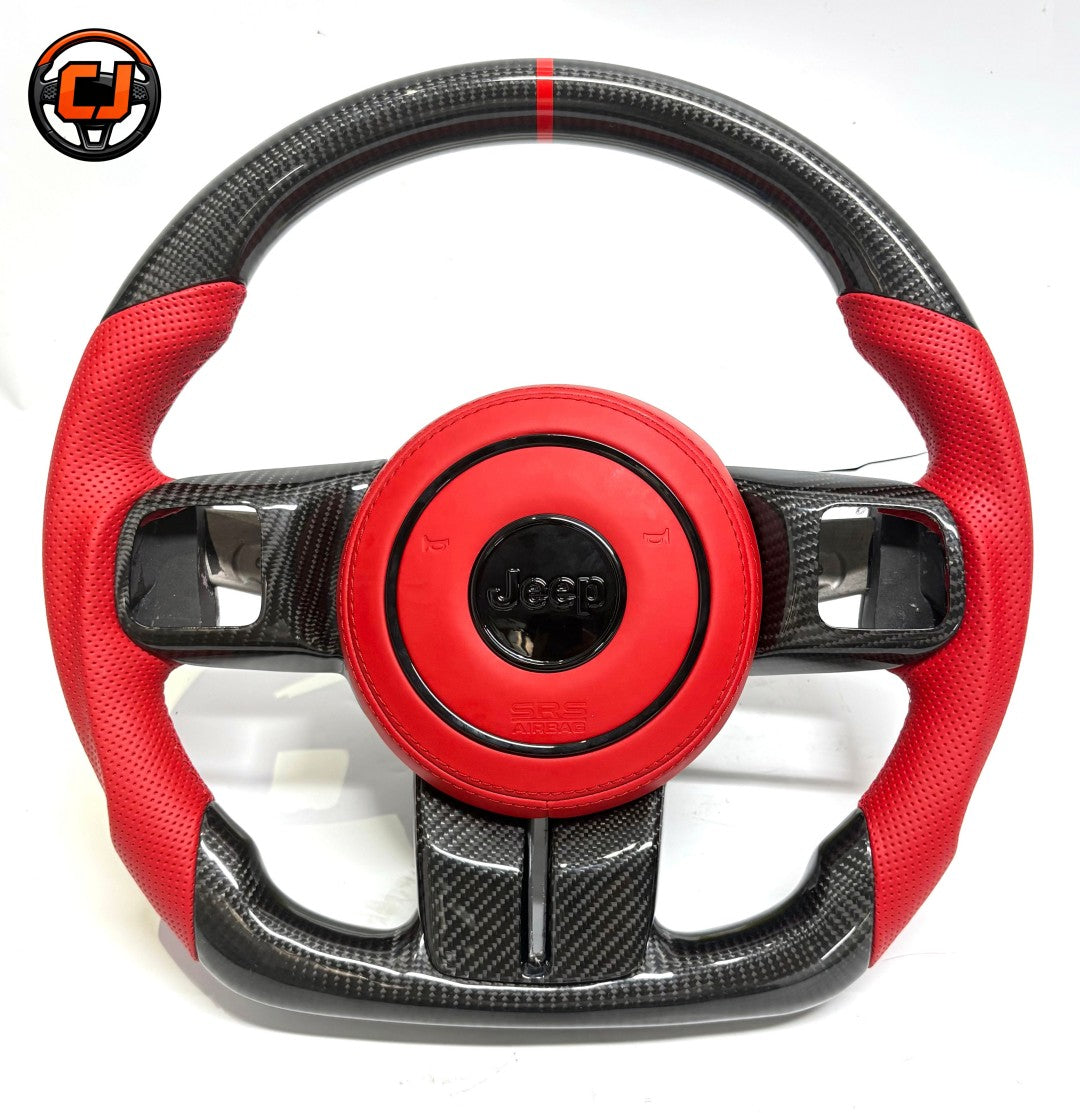 Studio front view of custom Jeep Wrangler carbon fiber steering wheel with red perforated leather grips, red leather airbag cover, red 12 o'clock stripe and flat bottom sport design