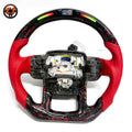 Custom Land Rover Range Rover carbon fiber steering wheel with red perforated leather grips, red flake forged carbon fiber flat bottom trim, LED shift lights, top digital display and exposed airbag mounting structure