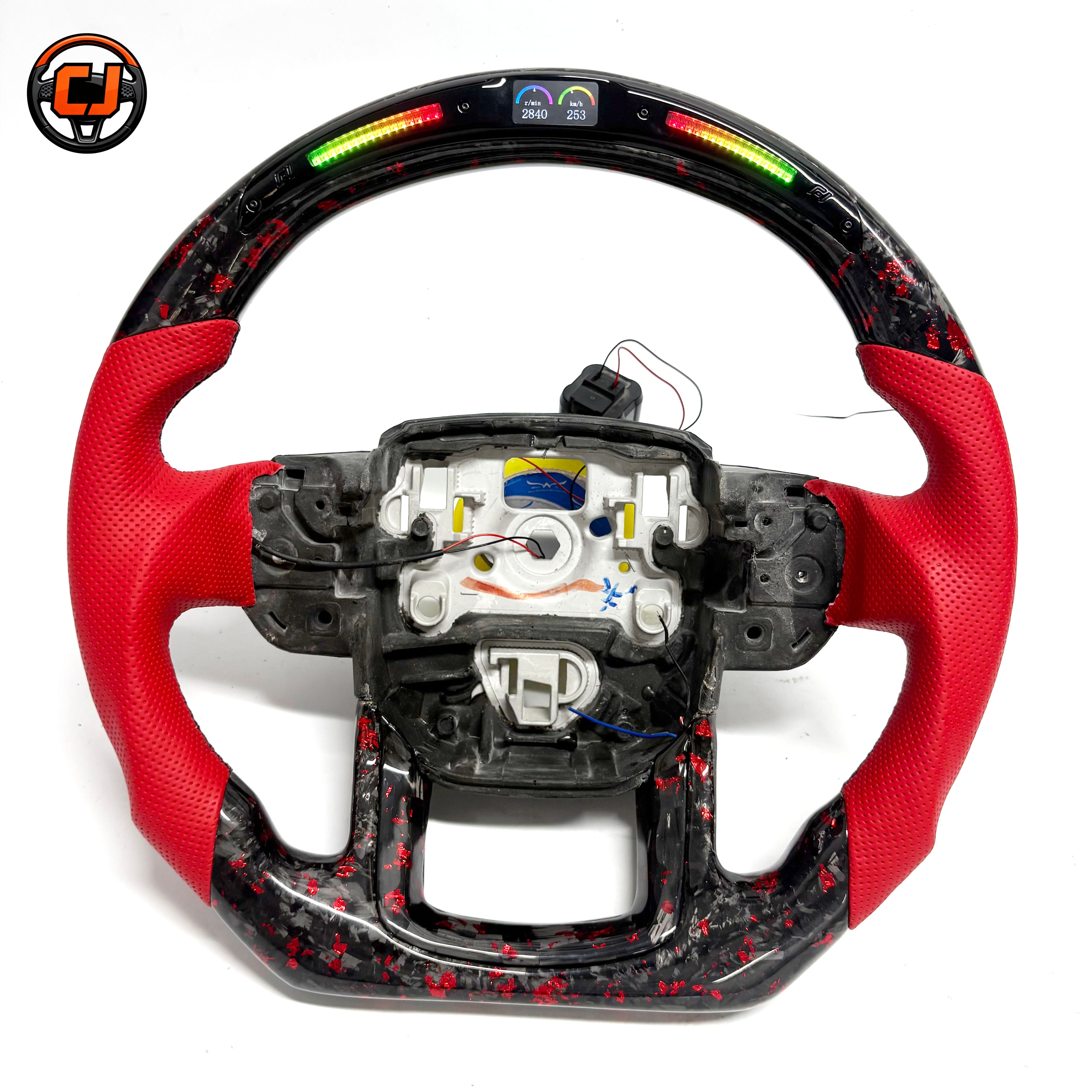 Custom Land Rover Range Rover carbon fiber steering wheel with red perforated leather grips, red flake forged carbon fiber flat bottom trim, LED shift lights, top digital display and exposed airbag mounting structure