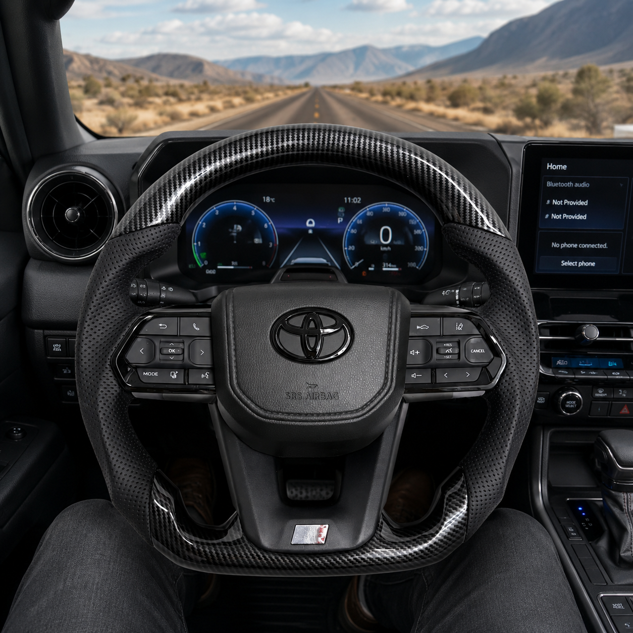 Toyota Land Cruiser LC300 custom hydro-dipped carbon style steering wheel with perforated leather grips and OEM multifunction controls installed in vehicle interior by CJ Mod Garage