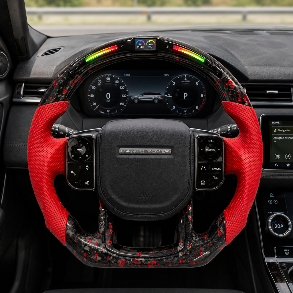 Custom Land Rover Range Rover carbon fiber steering wheel installed in car interior with red perforated leather grips, black airbag cover, red flake forged carbon fiber trim, LED shift lights and top display