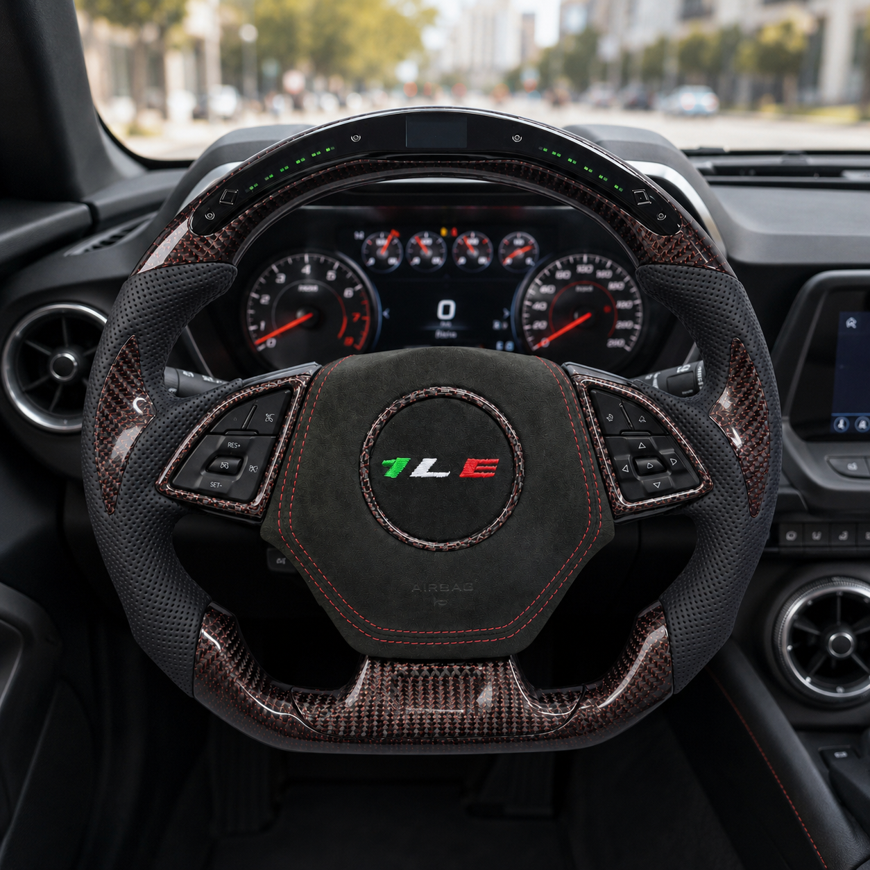 Front interior view of custom Chevrolet Camaro steering wheel with led display forged carbon trim perforated leather grips suede center and one le emblem