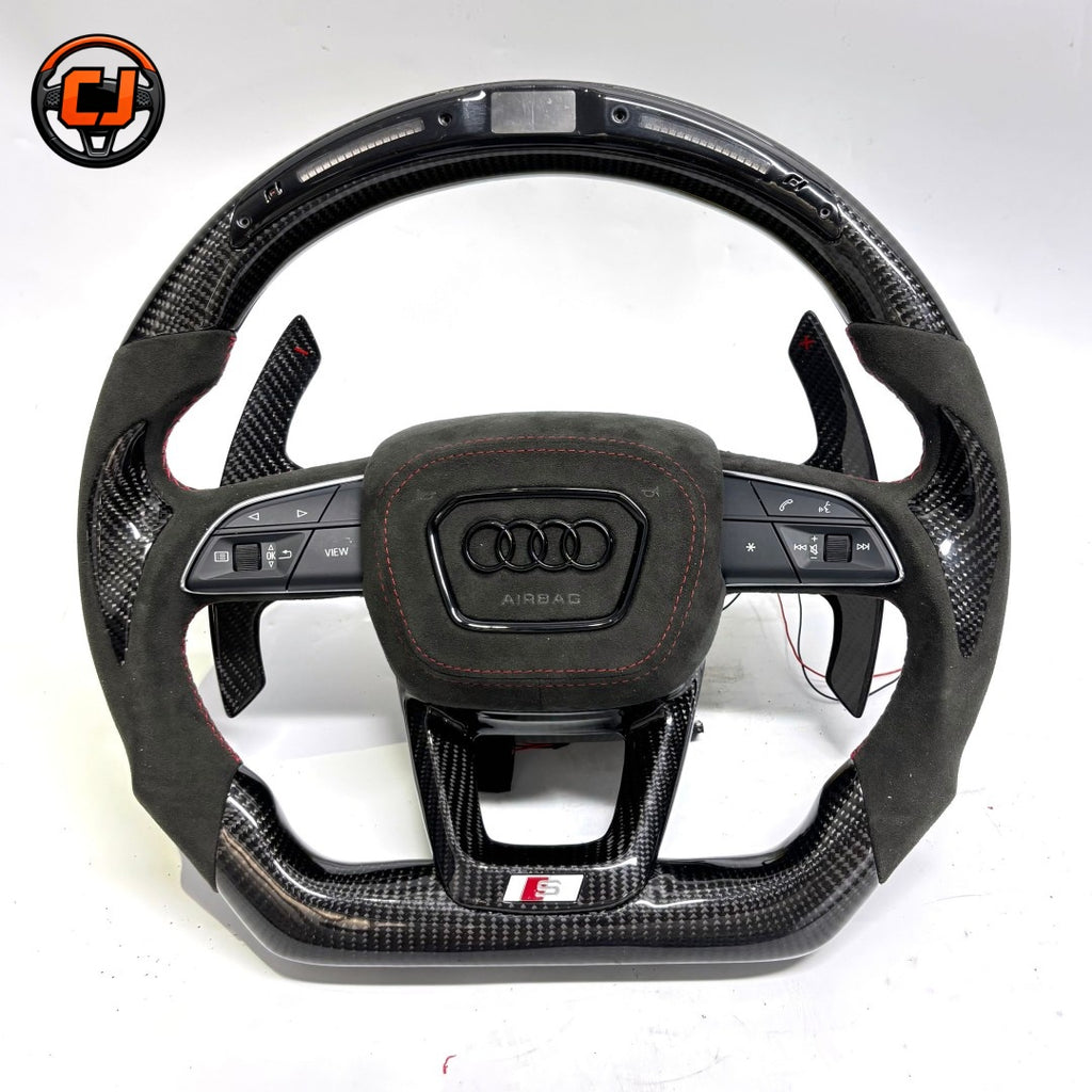 carbon fiber steering wheel, suede steering wheel audi, audi led steering wheel, audi custom steering wheel, audi a3 steering wheel, audi a4 steering wheel, audi a6 steering wheel, audi q5 steering wheel, audi q7 steering wheel, audi performance steering wheel, flat bottom steering wheel audi, audi sport steering wheel, red stripe steering wheel, luxury car steering wheel, aftermarket audi steering wheel