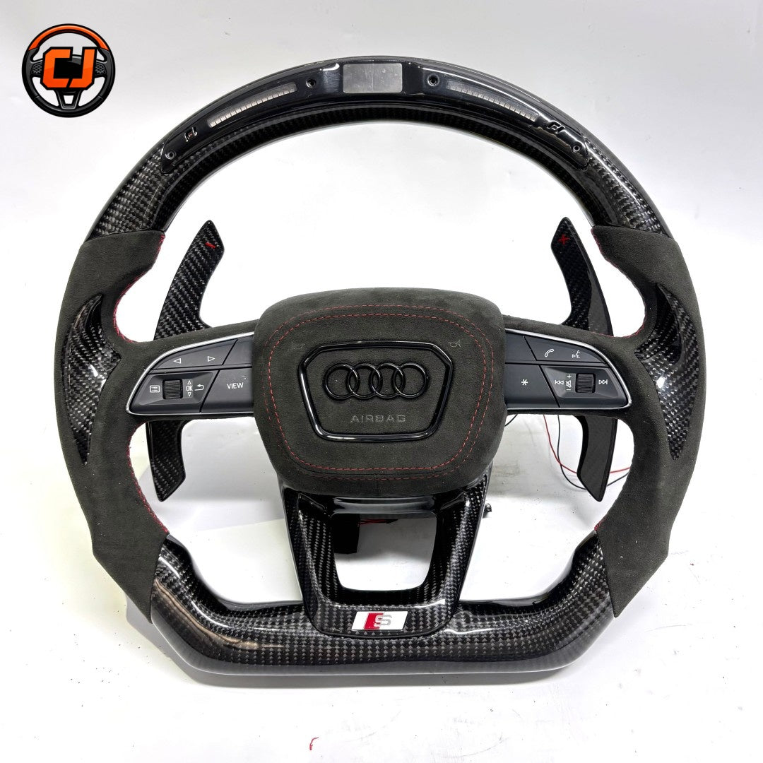 carbon fiber steering wheel, suede steering wheel audi, audi led steering wheel, audi custom steering wheel, audi a3 steering wheel, audi a4 steering wheel, audi a6 steering wheel, audi q5 steering wheel, audi q7 steering wheel, audi performance steering wheel, flat bottom steering wheel audi, audi sport steering wheel, red stripe steering wheel, luxury car steering wheel, aftermarket audi steering wheel