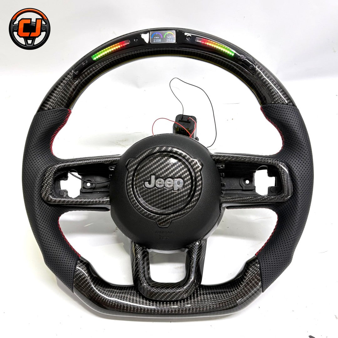 Studio product photo of custom Jeep Wrangler carbon fiber steering wheel with LED shift lights, top digital display, black perforated leather grips, flat bottom design and exposed button openings