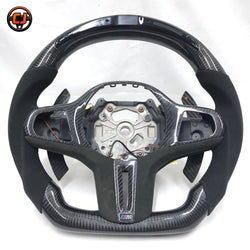 BMW G-chassis carbon fiber LED steering wheel frame on white background with Alcantara side grips, carbon paddle shifters, integrated LED display, and flat-bottom motorsport styling for BMW G02 G05 G06 G09 G11 G12 G15 G20 G22 G28 G29 G30 G38 G80 G82 F40 F90 by CJ Mod Garage