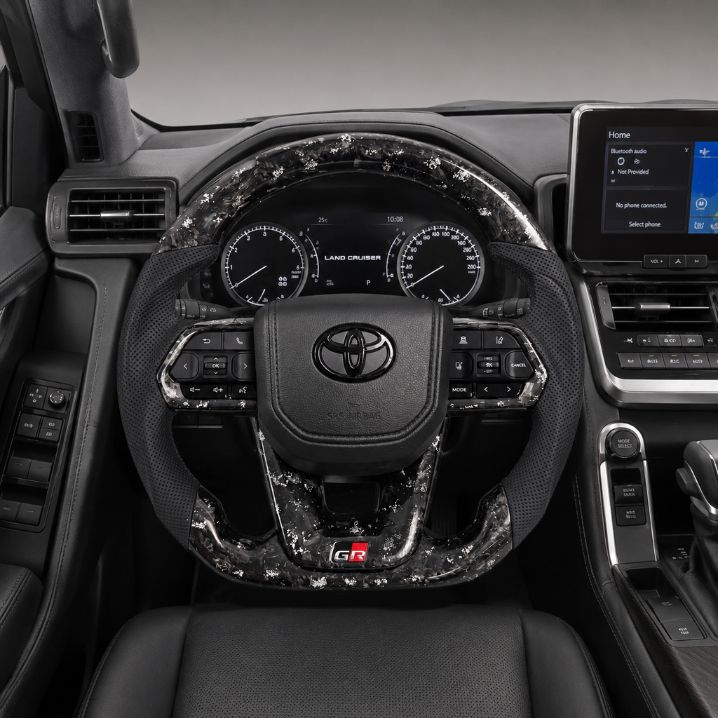 Toyota Land Cruiser LC300 custom steering wheel with white flake forged carbon finish, perforated leather grips, OEM controls and GR sport styling installed by CJ Mod Garage