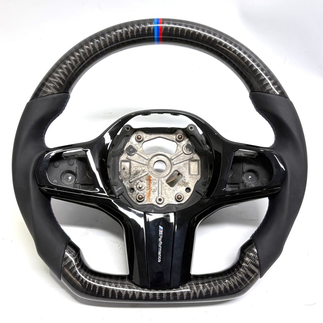 BMW custom flat-bottom carbon fiber steering wheel by CJ Mod Garage on white background with gloss black center trim, black leather side grips, M Performance badge, and motorsport-inspired design compatible with BMW G02 G05 G06 G09 G11 G12 G15 G20 G22 G28 G29 G30 G38 G80 G82 F40 F90