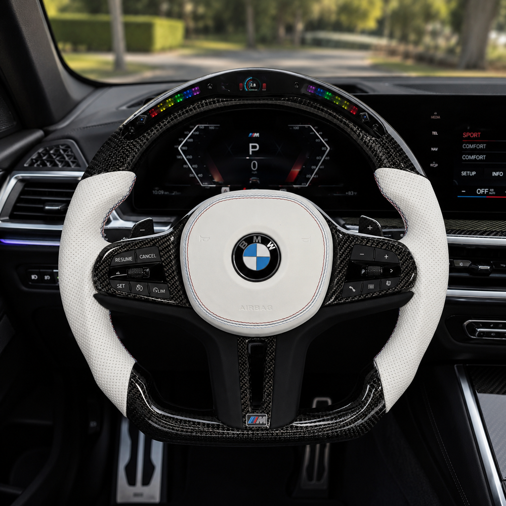 CJ Mod Garage BMW G-chassis custom LED carbon fiber steering wheel installed in BMW interior featuring gloss carbon fiber frame, integrated LED shift light display, white perforated leather grips, white airbag cover with M stitching, flat-bottom M Performance design, and sporty OEM+ styling compatible with BMW G02 G05 G06 G09 G11 G12 G15 G20 G22 G28 G29 G30 G38 G80 G82 F40 F90