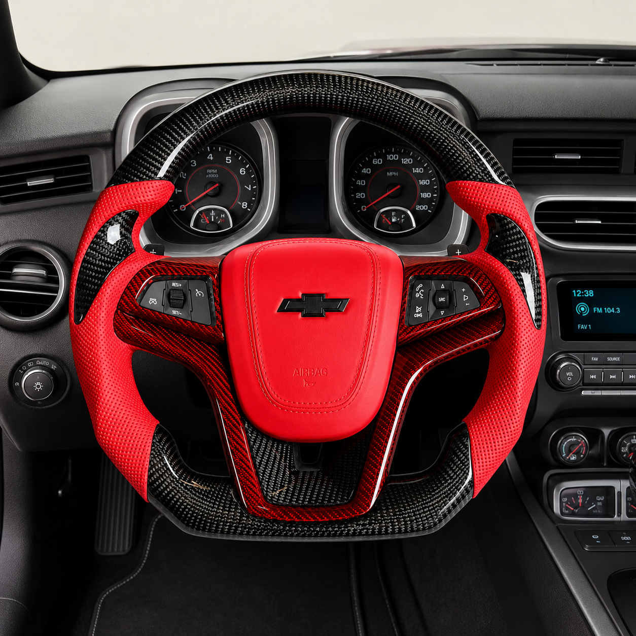 Custom Chevrolet Camaro carbon fiber steering wheel installed in car interior with red perforated leather grips red airbag cover gloss carbon fiber rim and red carbon trim