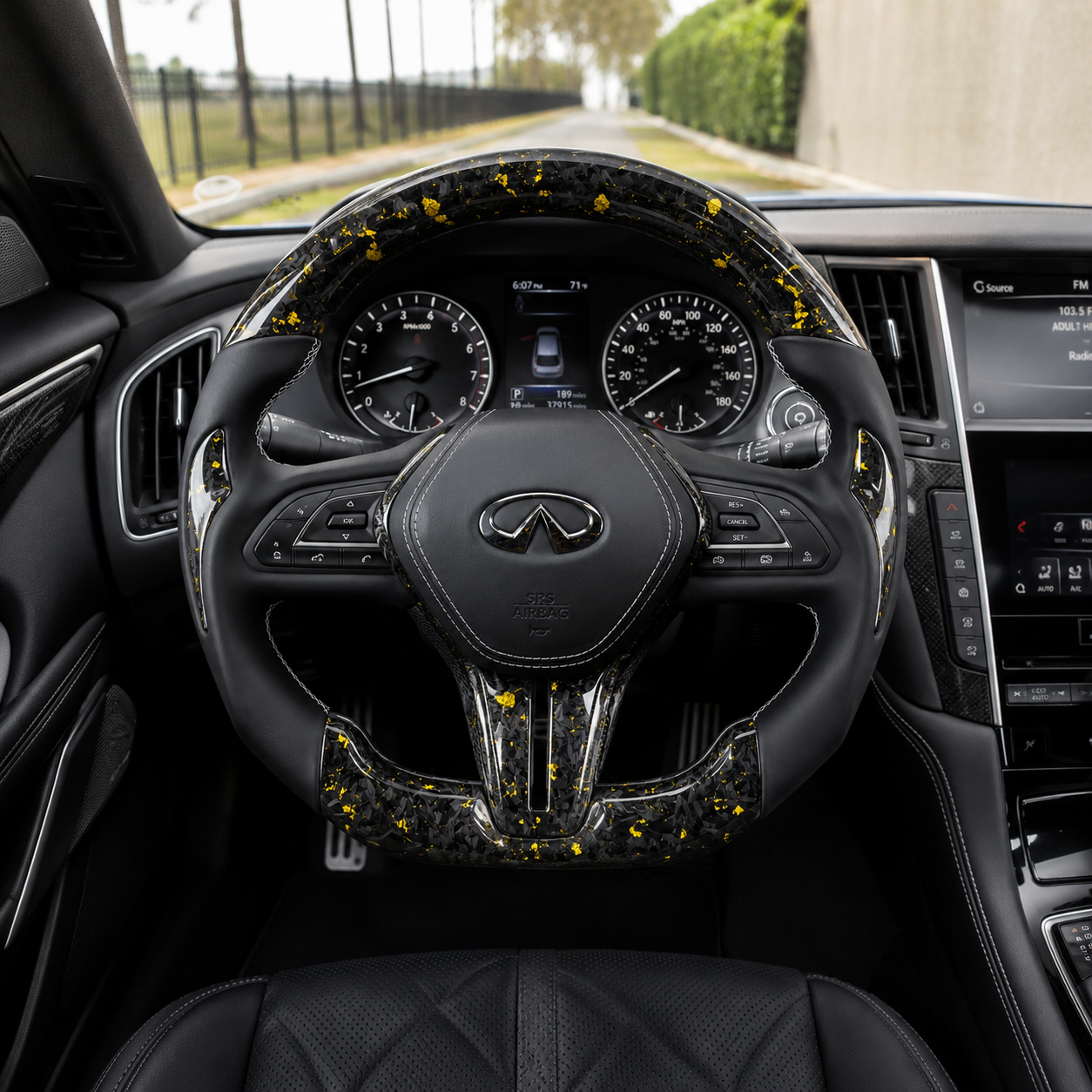 Infiniti Q60 forged carbon fiber steering wheel with gold flakes leather grips and white stitching installed in cockpit by CJ Mod Garage