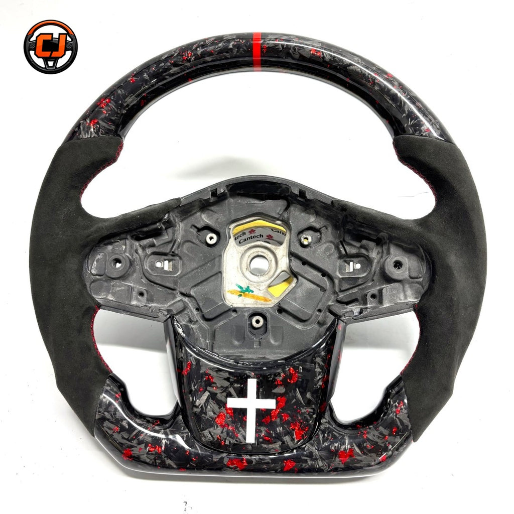 Toyota GR Supra A90 performance steering wheel in forged carbon composite with red flake finish, Alcantara leather grips and handcrafted racing-inspired design by CJ Mod Garage