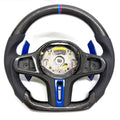 CJ Mod Garage BMW G-chassis custom carbon fiber steering wheel on white background featuring gloss carbon fiber top and bottom, black perforated leather grips, blue forged carbon center trim and paddle shifters, flat-bottom OEM+ sport design, compatible with BMW G02 G05 G06 G09 G11 G12 G15 G20 G22 G28 G29 G30 G38 G80 G82 F40 F90