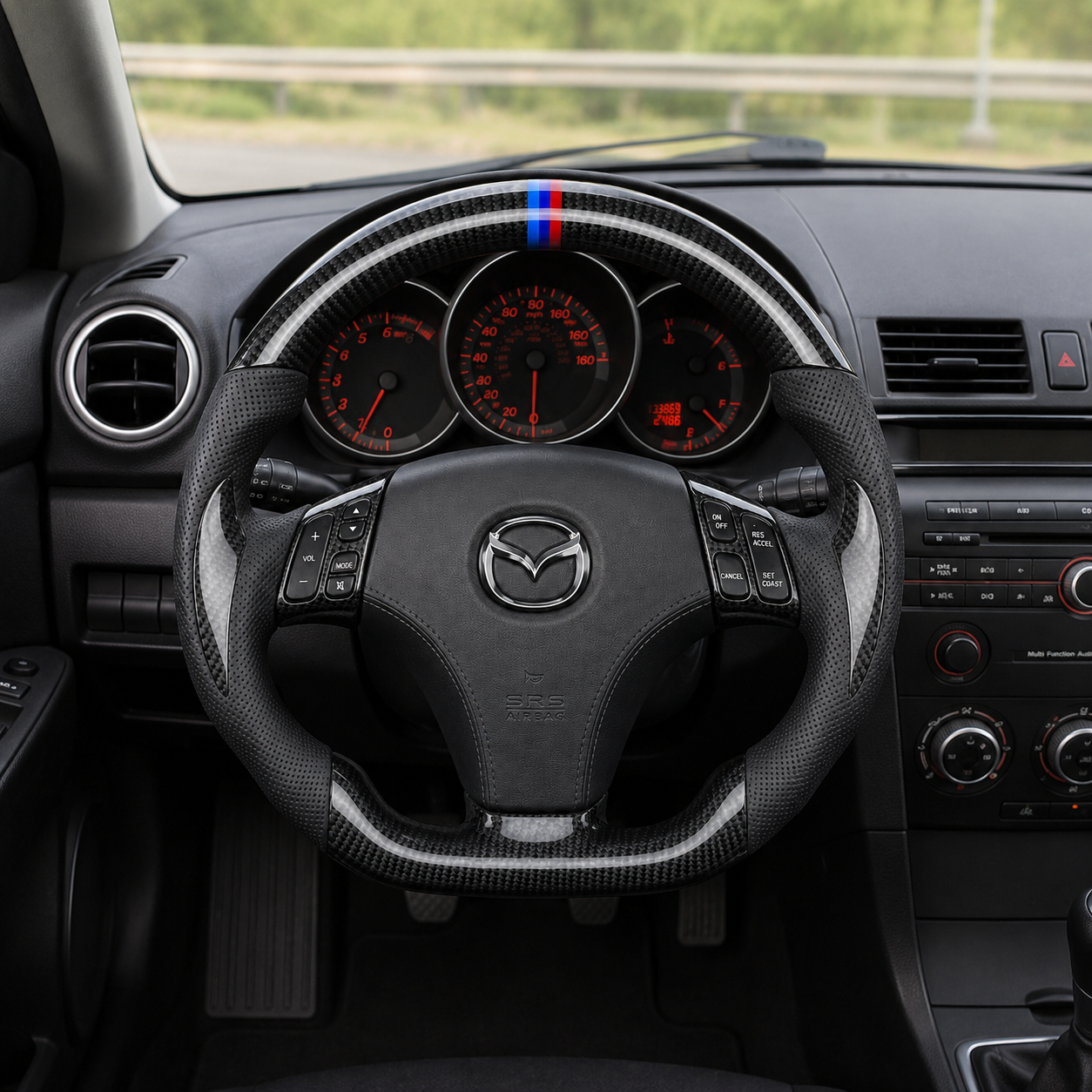 Custom Mazda steering wheel interior view for first generation Mazda platforms with carbon fiber trim perforated leather grips and tri color top marker
