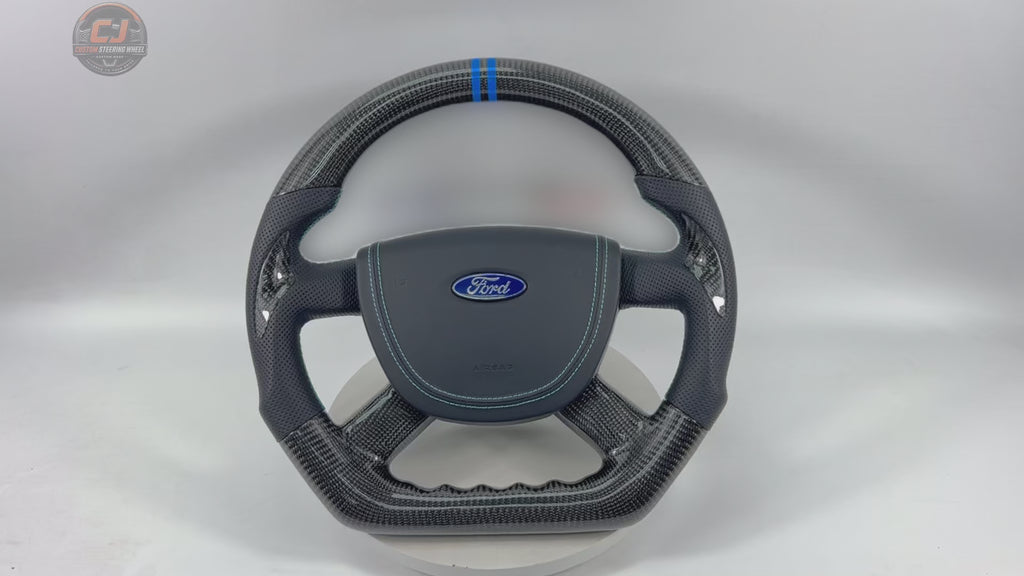 Rotating product video of Ford Focus RS ST carbon fiber steering wheel with perforated leather grips, blue stitching, blue 12 o’clock marker, airbag cover and sport contour design by CJ Mod Garage