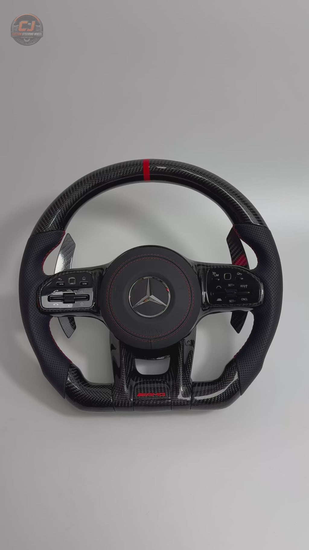 White background video showing Mercedes AMG custom carbon fiber steering wheel with red contrast stitching paddle shifters and sporty leather grips for W117 W176 W177 W203 W204 W205 W211 W212 W213 W218 C43 C63 C200 C300 by CJ Mod Garage