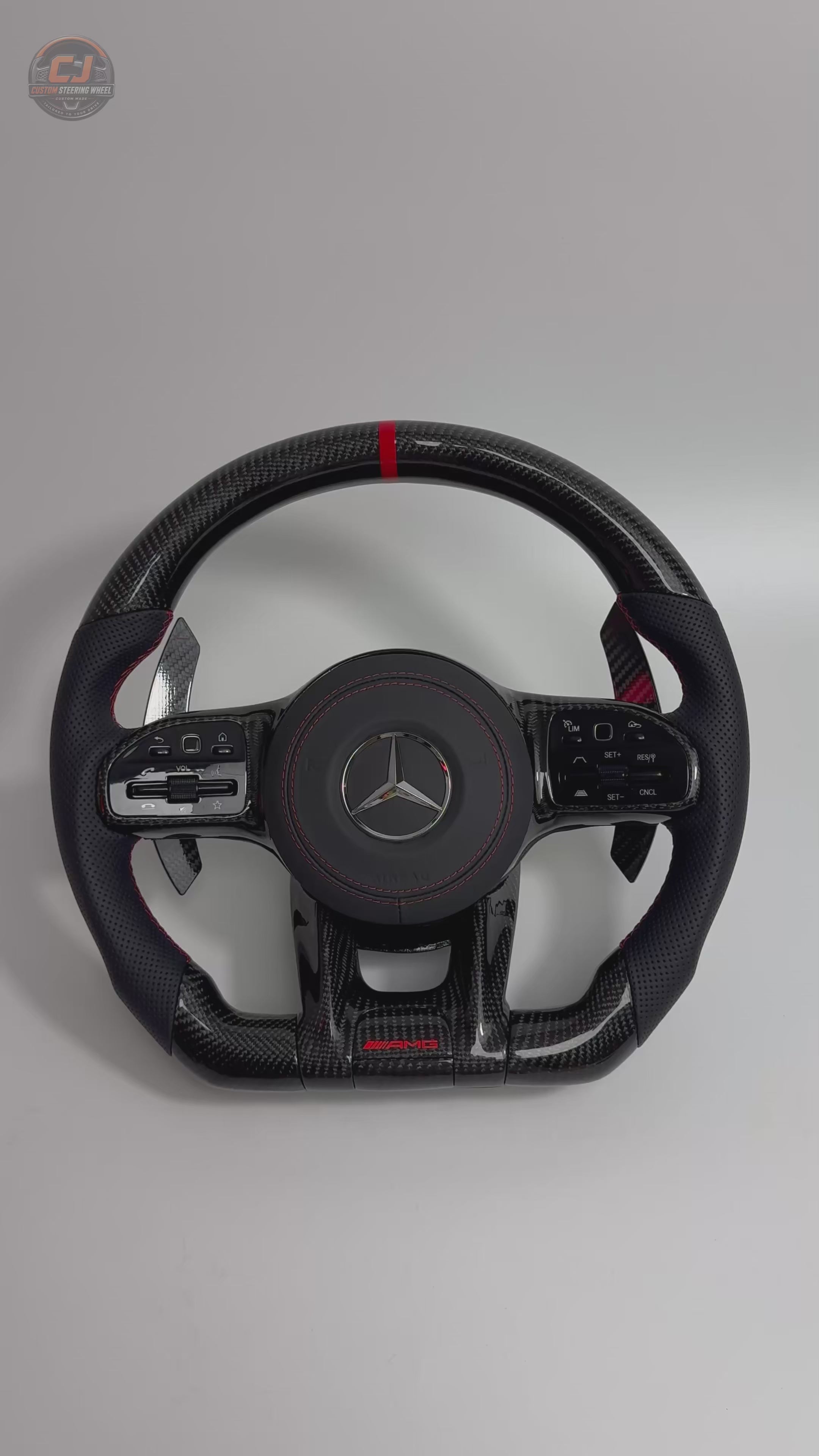 White background video showing Mercedes AMG custom carbon fiber steering wheel with red contrast stitching paddle shifters and sporty leather grips for W117 W176 W177 W203 W204 W205 W211 W212 W213 W218 C43 C63 C200 C300 by CJ Mod Garage